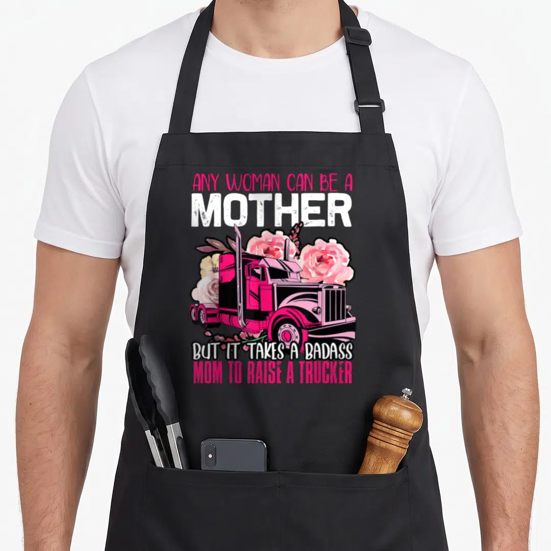 Badass truck apron - Pink semi-truck surrounded by roses with text honoring trucker mothers — shown on a black cotton canvas apron against a white background
