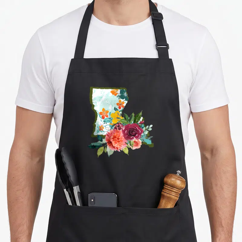 Watercolor louisiana apron - Louisiana state map silhouette filled with light blue texture and watercolor flowers — shown on a black cotton canvas apron against a white background