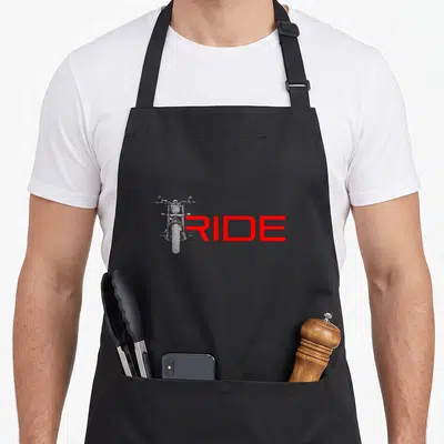 Retro motorcycle apron - White line-art motorcycle overlapping red RIDE text on black fabric — shown on a black cotton canvas apron against a white background