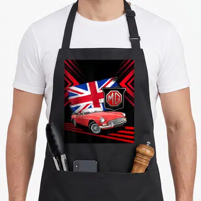Convertible car apron - Red MG convertible car with distressed flag and shield logo on black background — shown on a black cotton canvas apron against a white background