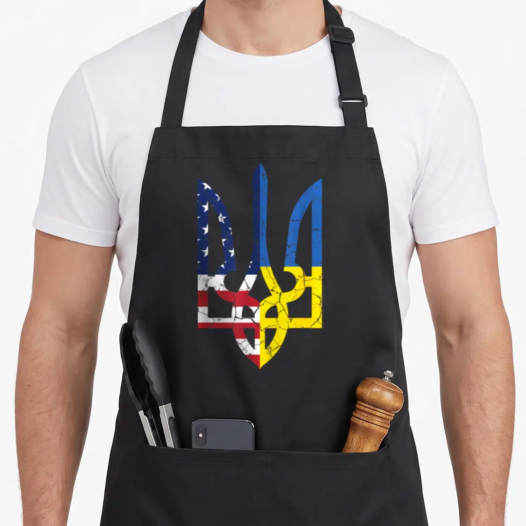 Symbol american flag apron - Distressed trident split vertically with US stars stripes and Ukrainian blue yellow flags — shown on a black cotton canvas apron against a white background