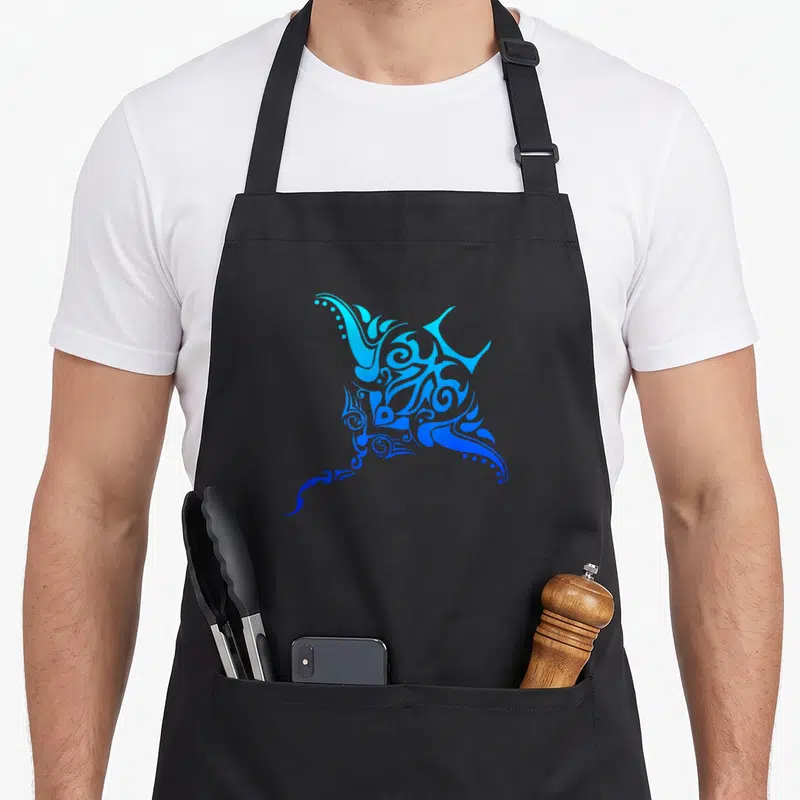 Hawaiian tattoo apron - Stylized stingray with cyan to blue gradient and ornate swirls in line-art style — shown on a black cotton canvas apron against a white background