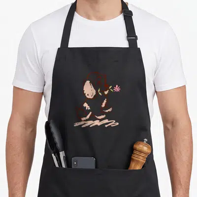 Puppy lady and the tramp apron - Brown line art puppy sitting holding a pink flower in mouth — shown on a black cotton canvas apron against a white background