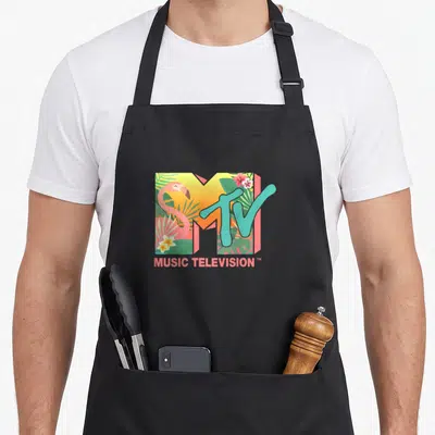 Mtv flamingo apron - MTV logo filled with pink flamingo, green leaves, and yellow flowers, MUSIC TELEVISION text below — shown on a black cotton canvas apron against a white background