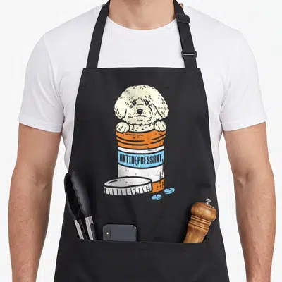 Medicine dog apron - Cream cartoon dog inside orange pill bottle labeled ANTIDEPRESSANT with blue pills — shown on a black cotton canvas apron against a white background