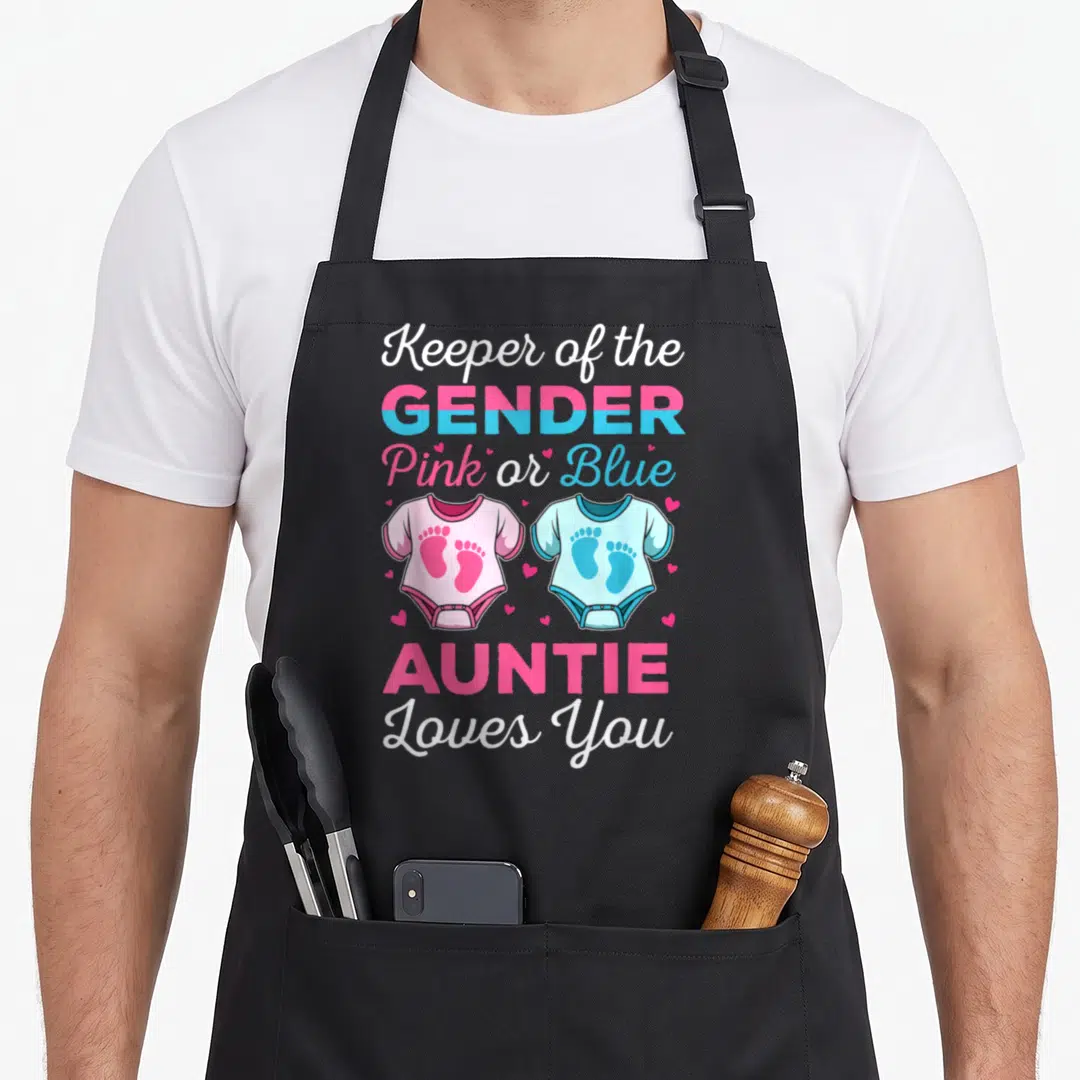 Auntie gender reveal co apron - Pink and blue onesies with footprints and stacked text reading Keeper of the Gender — shown on a black cotton canvas apron against a white background