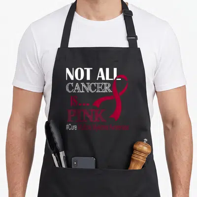 Cancer myeloma awareness apron - Stacked text NOT ALL CANCER IS PINK with red ribbon and three hearts on black bib — shown on a black cotton canvas apron against a white background