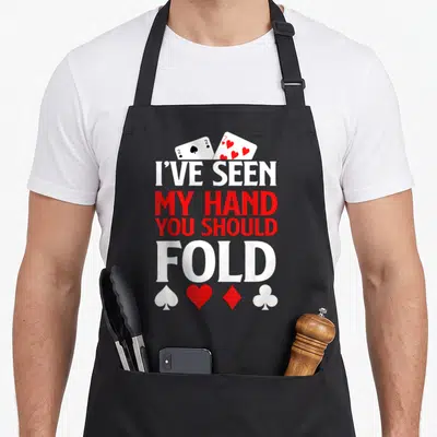 Chip texas apron - Two playing cards above stacked text reading I've seen my hand you should fold with four suit — shown on a black cotton canvas apron against a white background