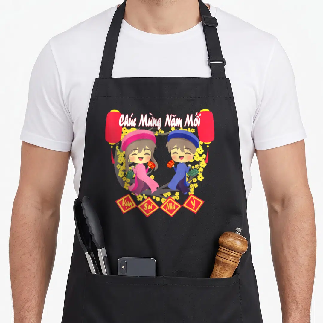 Funny lunar vietnamese girl apron - Two children on flowering branch with red lanterns and diamond shapes reading Vạn — shown on a black cotton canvas apron against a white background