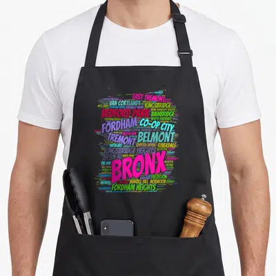 Boogie new york apron - Colorful word cloud of Bronx neighborhoods like Fordham and Riverdale with large pink BRONX — shown on a black cotton canvas apron against a white background