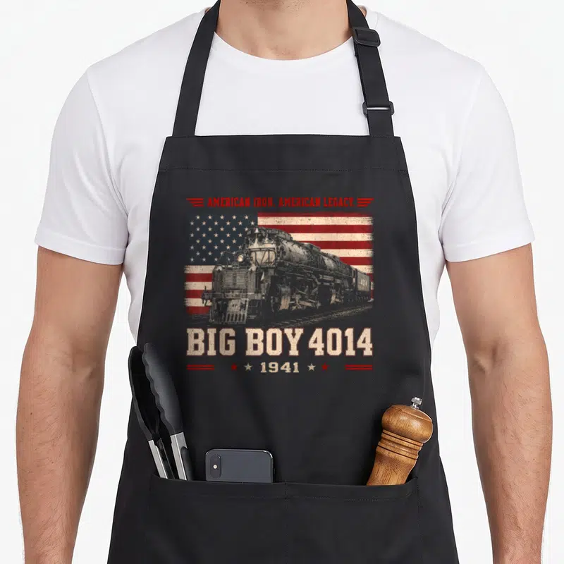 Railroad steam locomotive apron - Big Boy 4014 steam engine graphic with American Iron text over distressed flag — shown on a black cotton canvas apron against a white background