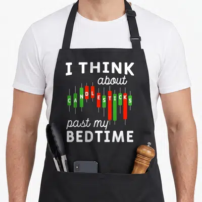 Candle stock aprons - I THINK about CANDLESTICKS past my BEDTIME text with red and green chart bars — shown on a black cotton canvas apron against a white background