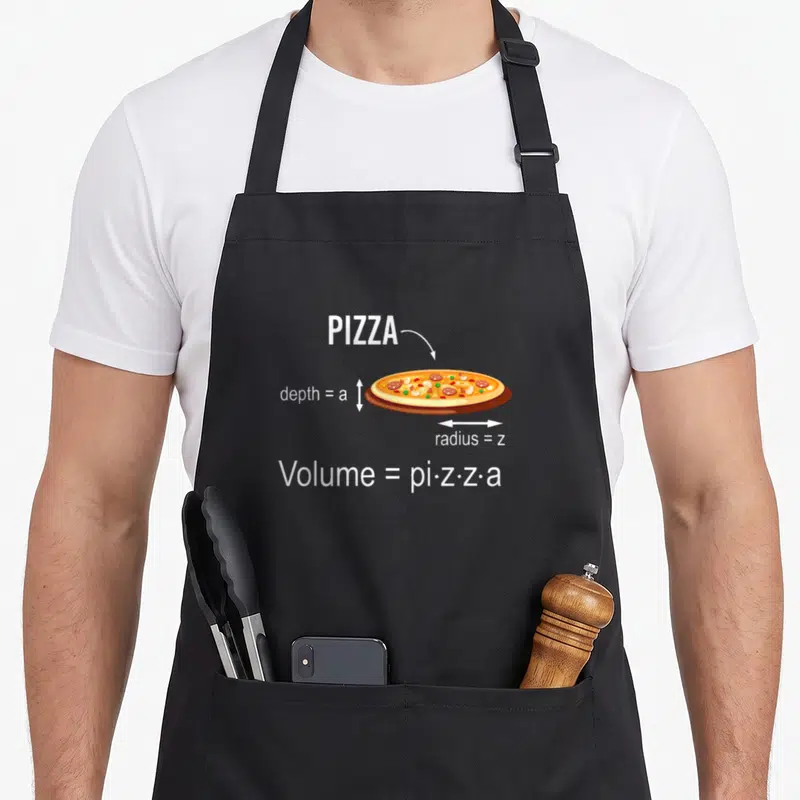 Math pizza apron - Pizza diagram with labels depth=a radius=z and formula — shown on a black cotton canvas apron against a white background