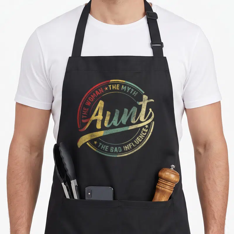 Aunt best stepmom ever apron - Distressed circular text design reading Aunt The Woman The Myth The Bad Influence in red — shown on a black cotton canvas apron against a white background