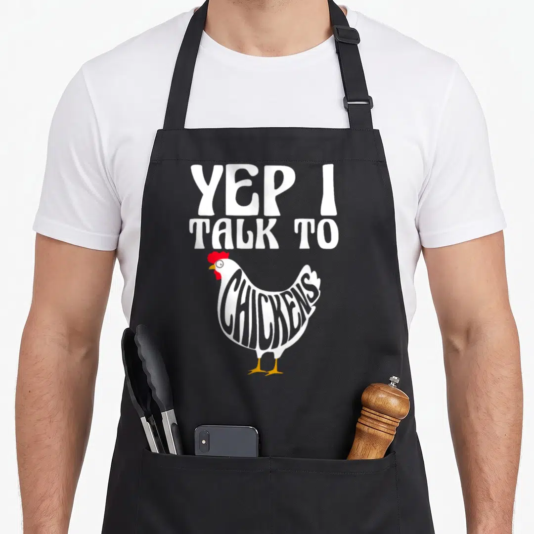 Retro farmer animal chicken apron - Cartoon chicken with YEP I TALK TO CHICKENS text inside body — shown on a black cotton canvas apron against a white background
