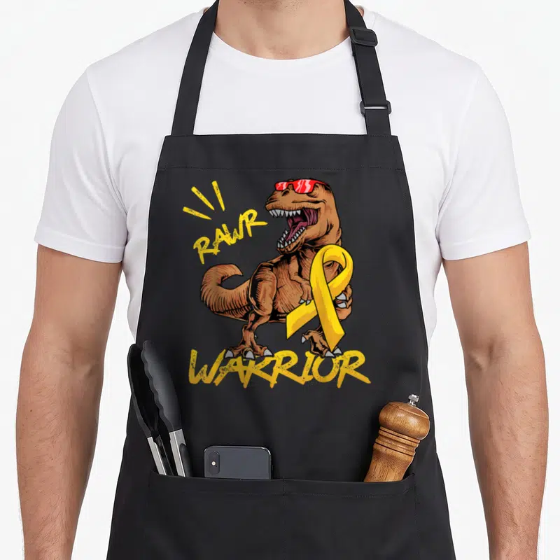 Rex ribbon apron - Brown T-Rex wearing red sunglasses and holding a yellow ribbon with RAWR WARRIOR text in yellow — shown on a black cotton canvas apron against a white background