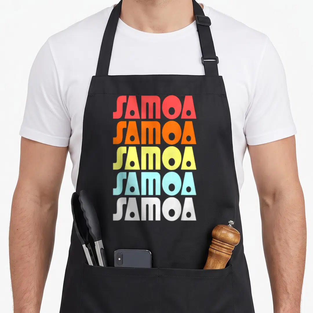 Cute samoan samoa apron - Five stacked SAMOA words in red orange yellow light blue and white block letters — shown on a black cotton canvas apron against a white background