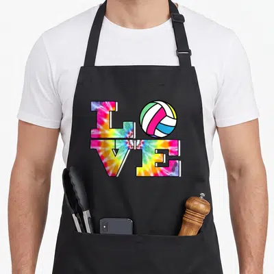Volleyball colorful tie-dye apron - LOVE typography grid with volleyball replacing O in pink yellow blue green white — shown on a black cotton canvas apron against a white background