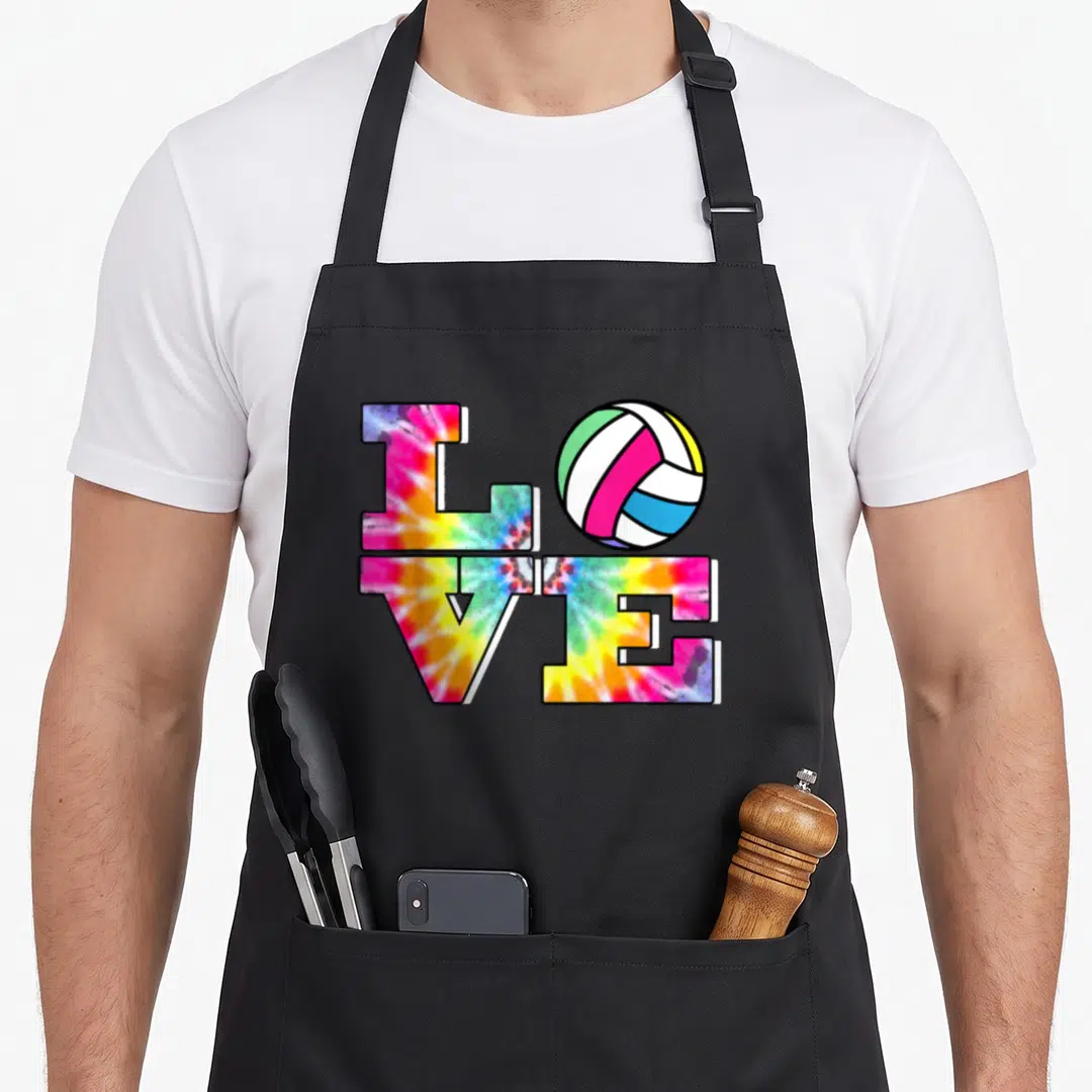 Volleyball colorful tie-dye apron - LOVE typography grid with volleyball replacing O in pink yellow blue green white — shown on a black cotton canvas apron against a white background