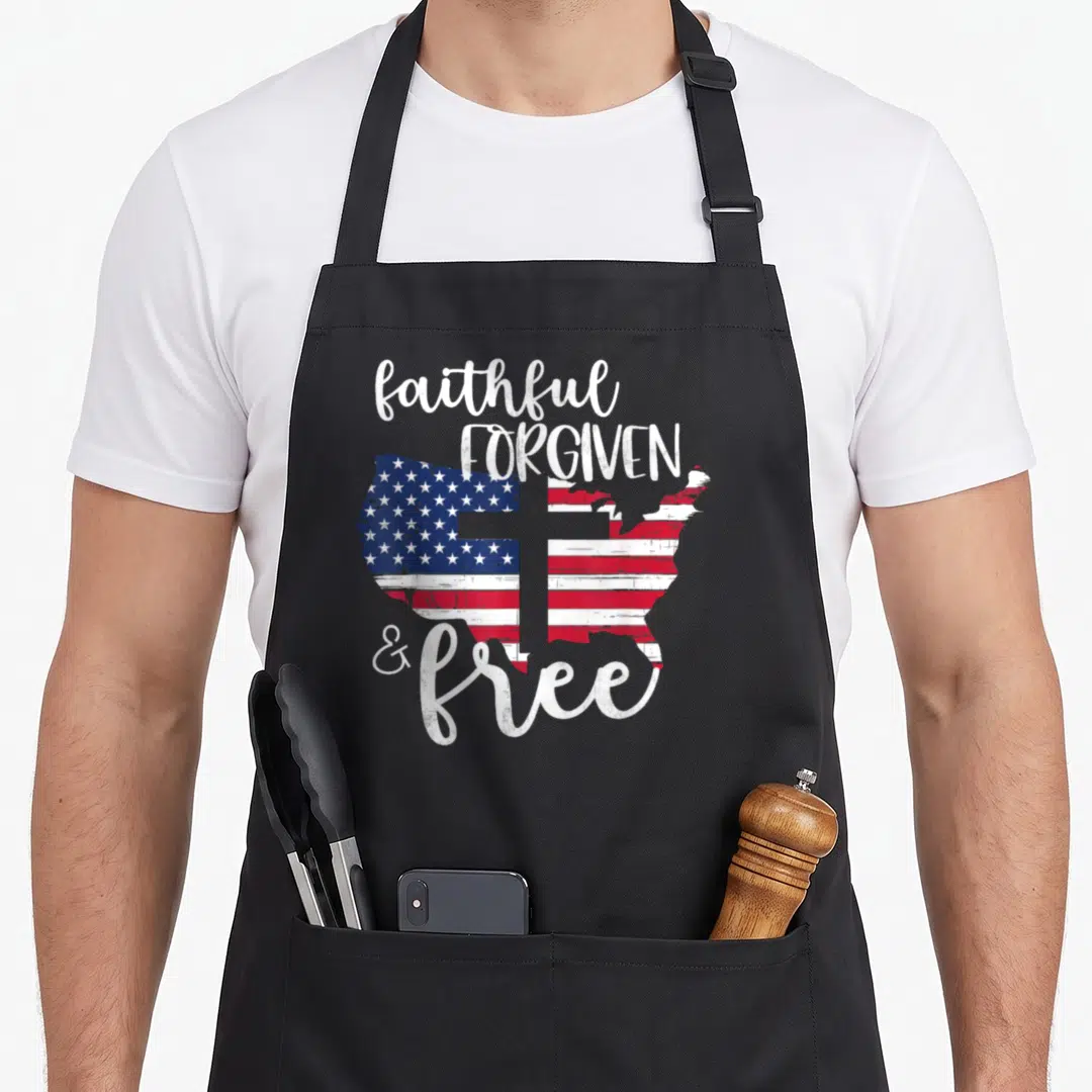 Faithful 4th of july apron - Distressed USA map with red white blue flag pattern and white cross overlaid by text — shown on a black cotton canvas apron against a white background