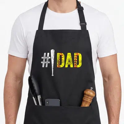 Number softball father day apron - White hashtag and bat next to yellow DAD with red stitching on black background — shown on a black cotton canvas apron against a white background