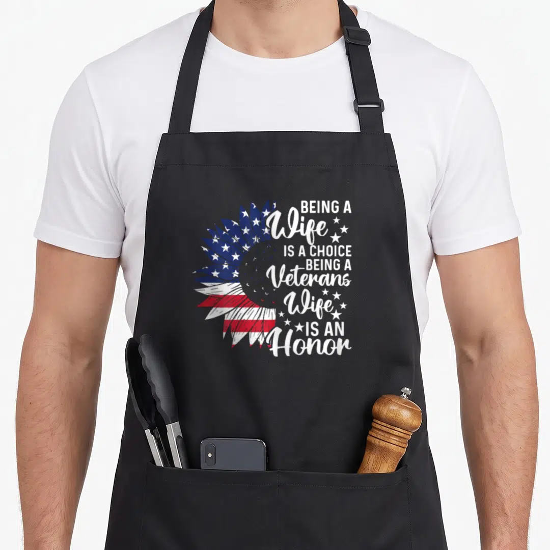 Honor patriotic apron - Sunflower with red white and blue flag pattern and stacked text about veterans wife honor — shown on a black cotton canvas apron against a white background