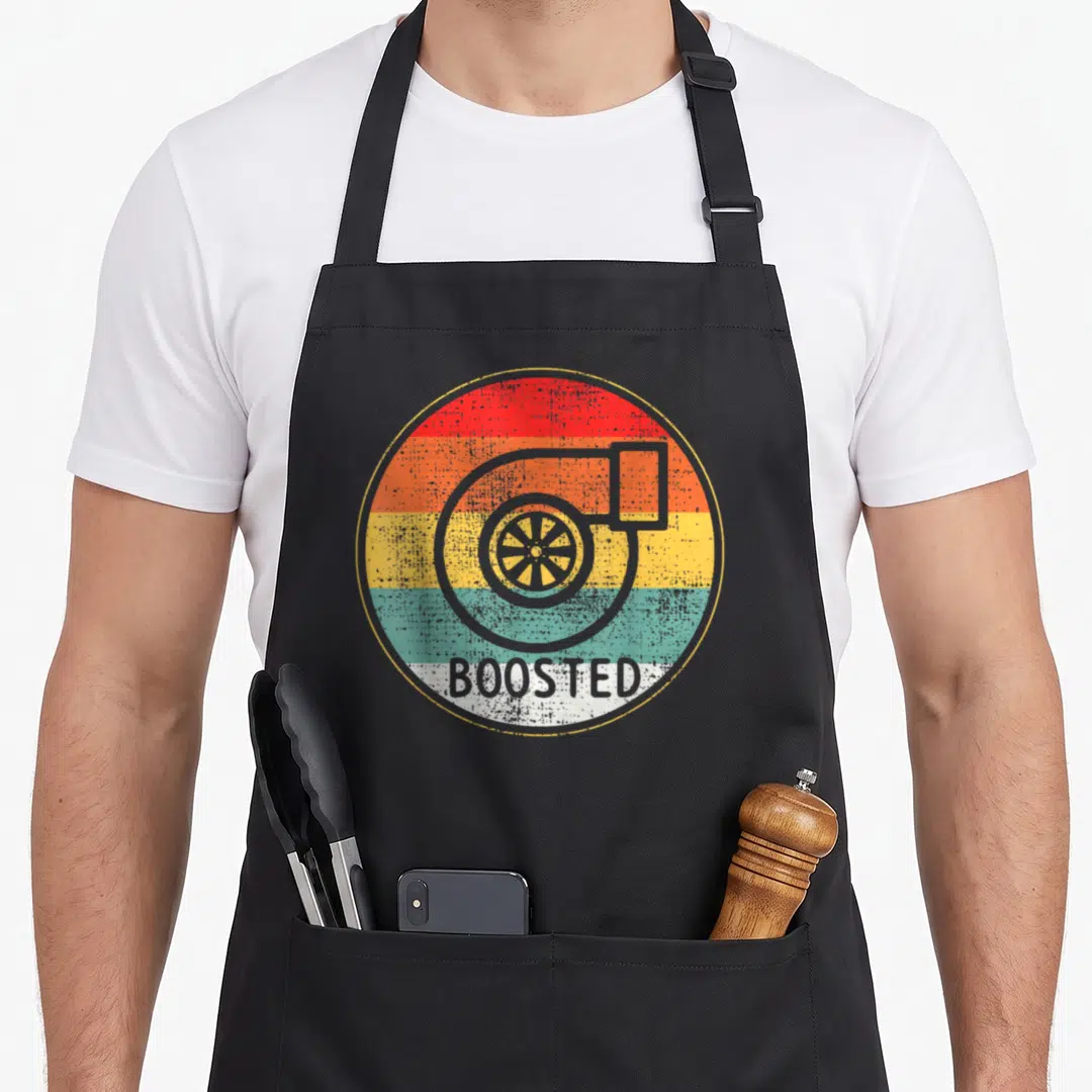 Tuner car apron - Grey turbocharger outline on red orange yellow teal and white horizontal stripes with BOOSTED text — shown on a black cotton canvas apron against a white background