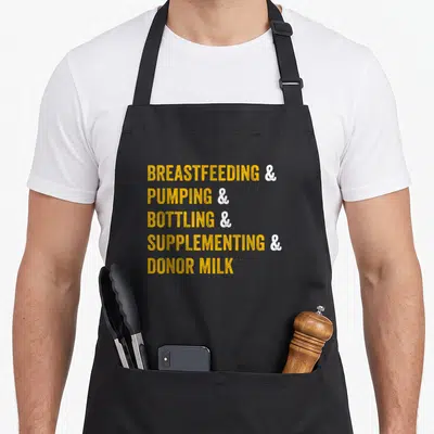 Specialist consultant apron - Yellow and white stacked text reading BREASTFEEDING PUMPING BOTTLING SUPPLEMENTING DONOR — shown on a black cotton canvas apron against a white background