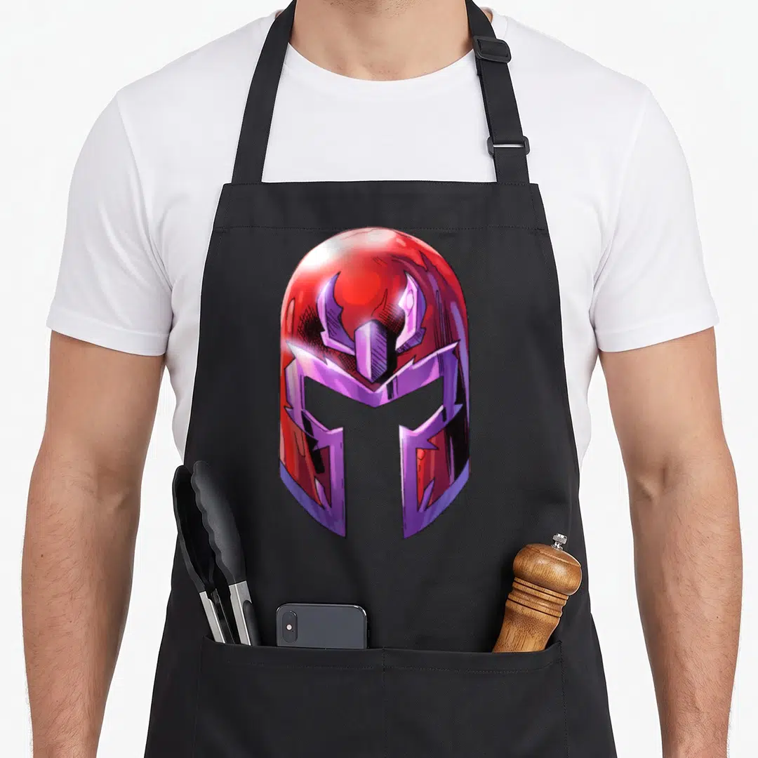 Magneto holiday apron - Red and purple cartoon helmet centered on apron front panel — shown on a black cotton canvas apron against a white background