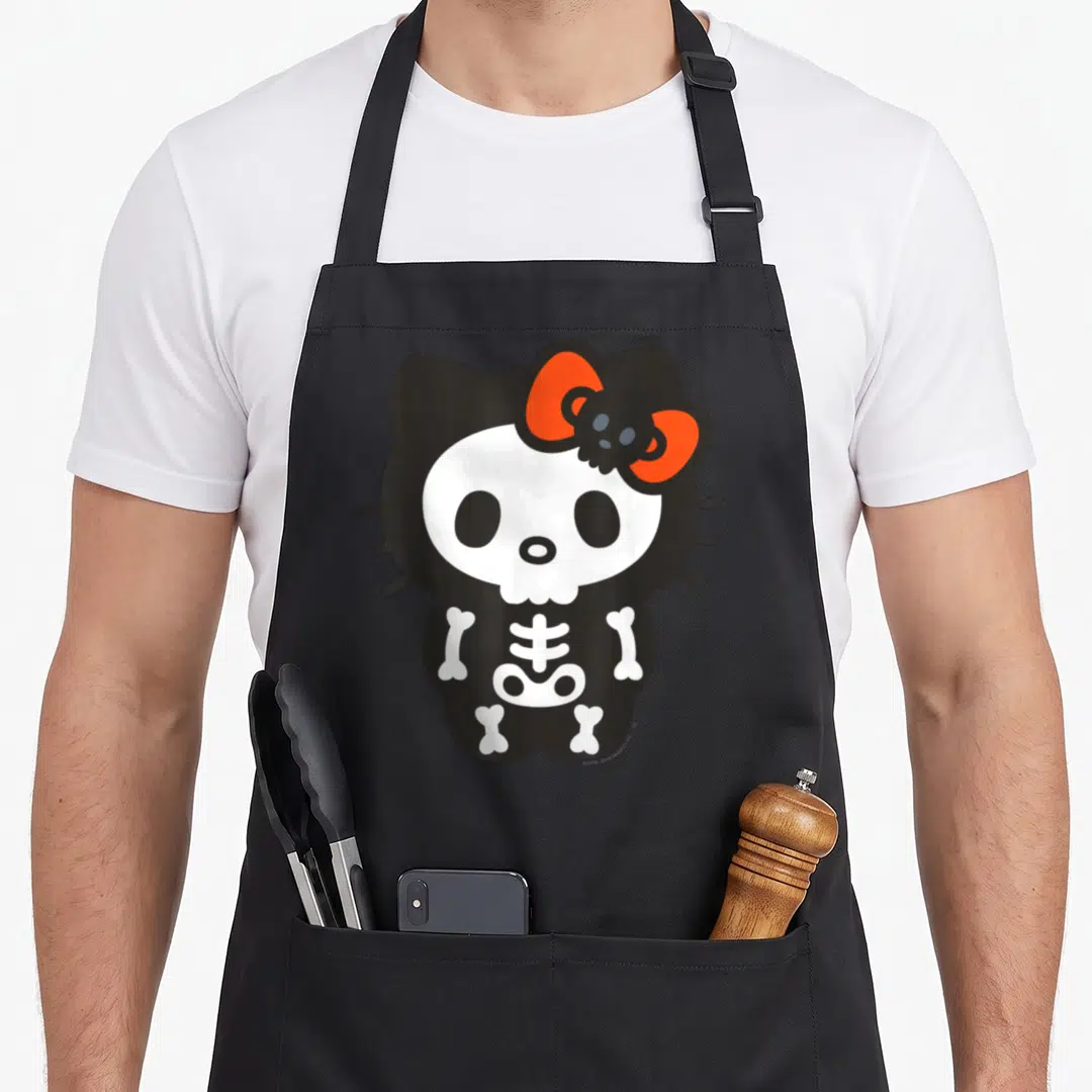 Halloween skeleton apron - Cartoon skeleton cat with white bones and orange bow on black background — shown on a black cotton canvas apron against a white background