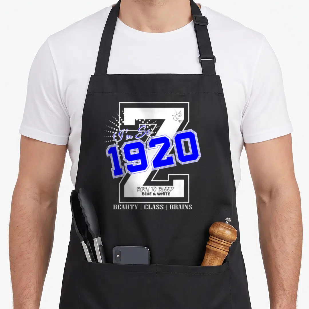 Zeta 1920s apron - Blue 1920 number over grey Z with bird and stacked white text reading Born to Bleed Blue and White — shown on a black cotton canvas apron against a white background