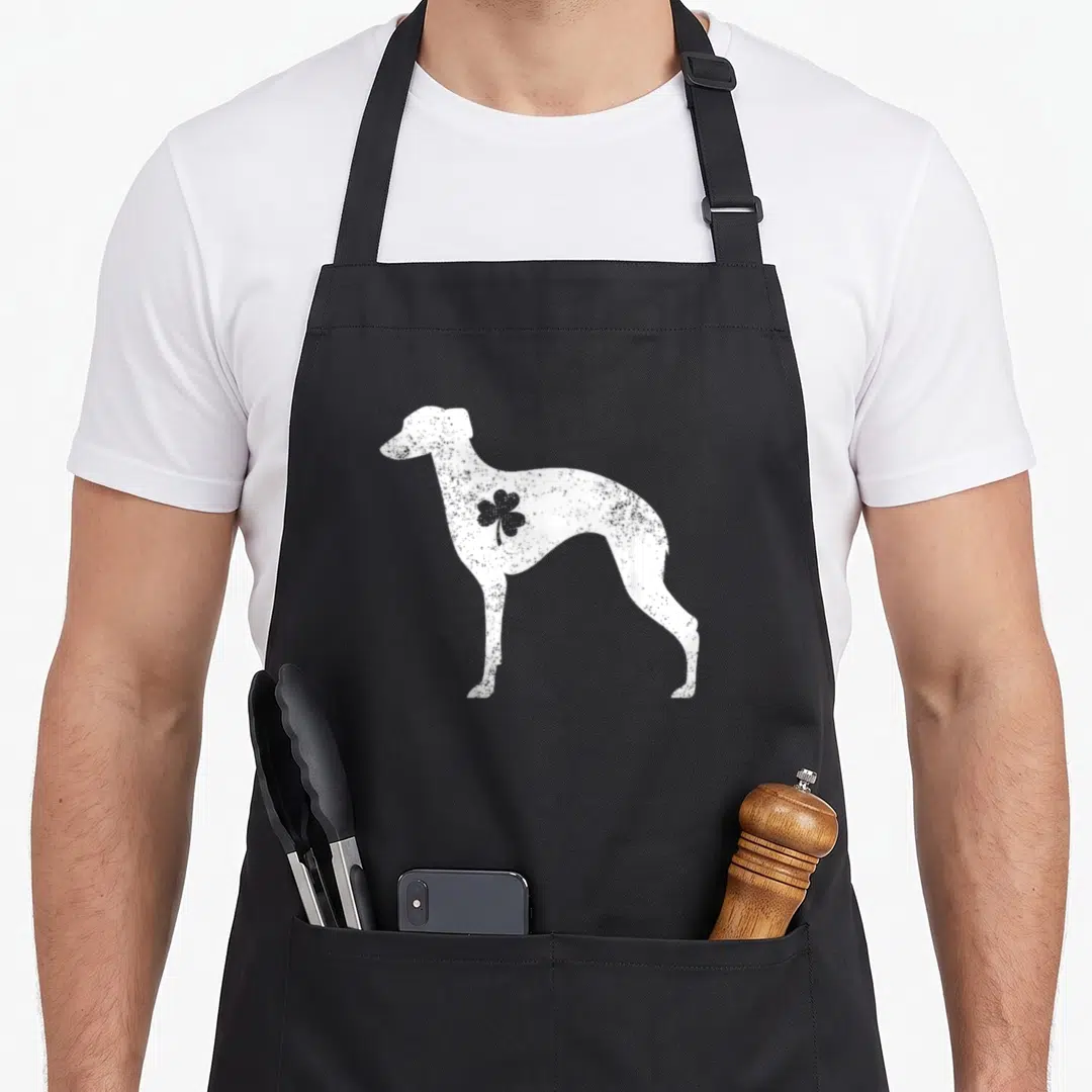 Whippet st patrick day aprons - White distressed whippet silhouette with grey shamrock on shoulder — shown on a black cotton canvas apron against a white background