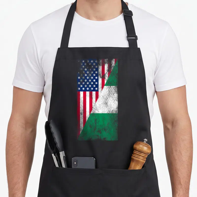 State nigerian apron - Merged USA and Nigeria flags split diagonally in red white blue green distressed style — shown on a black cotton canvas apron against a white background