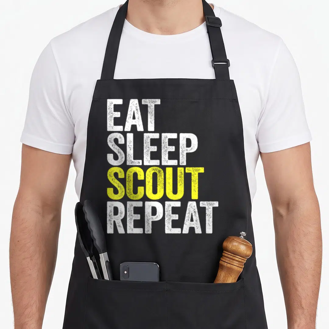 Eat rest day apron - Stacked EAT SLEEP SCOUT REPEAT text in white and yellow distressed font — shown on a black cotton canvas apron against a white background