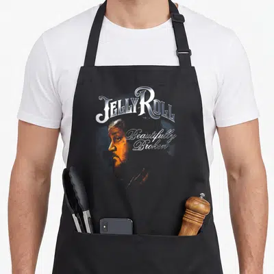Blue jelly apron - Jelly Roll profile portrait with Beautifully Broken script in orange blue and silver — shown on a black cotton canvas apron against a white background