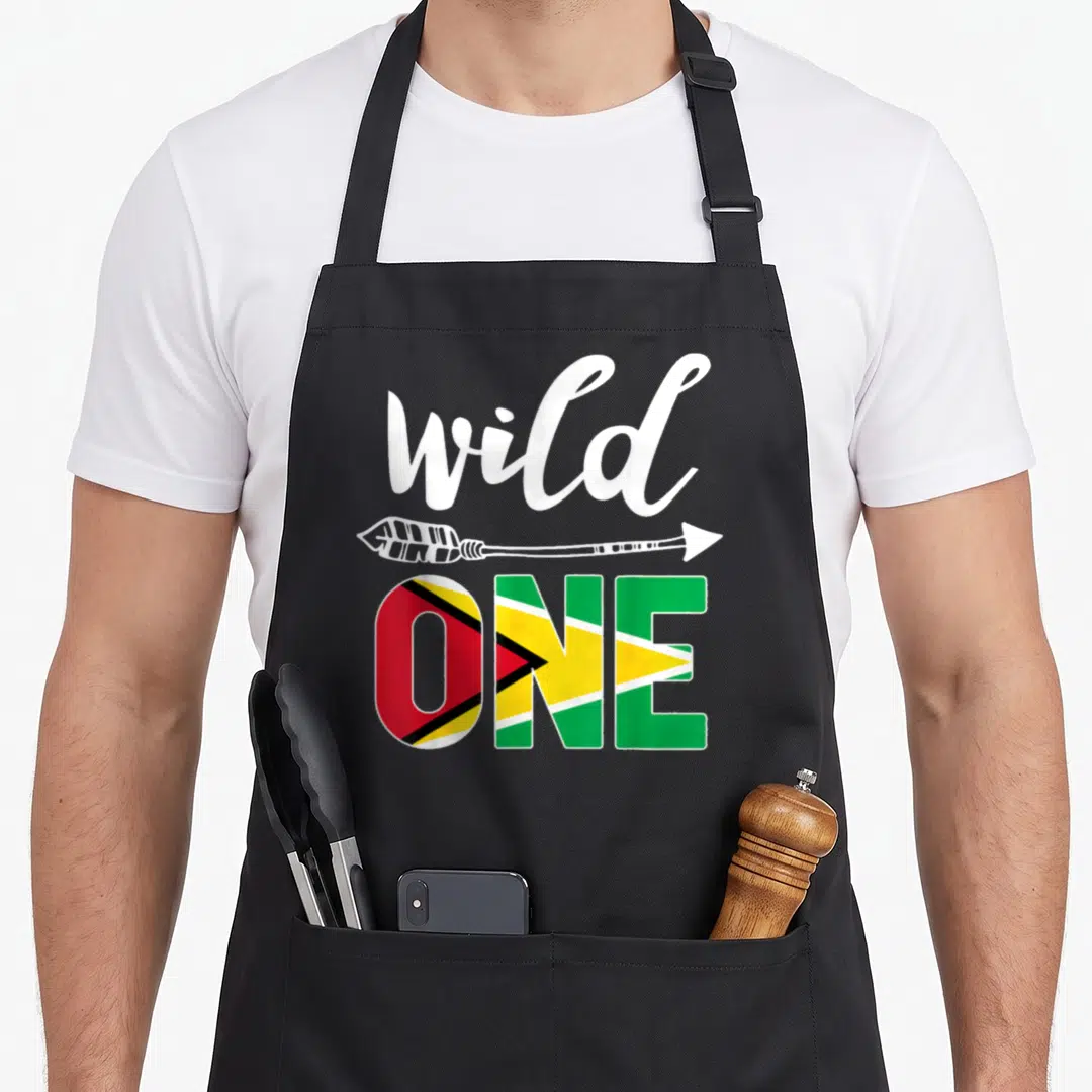 Guyana birthday apron - Wild ONE text with arrow and Guyana flag pattern fill — shown on a black cotton canvas apron against a white background