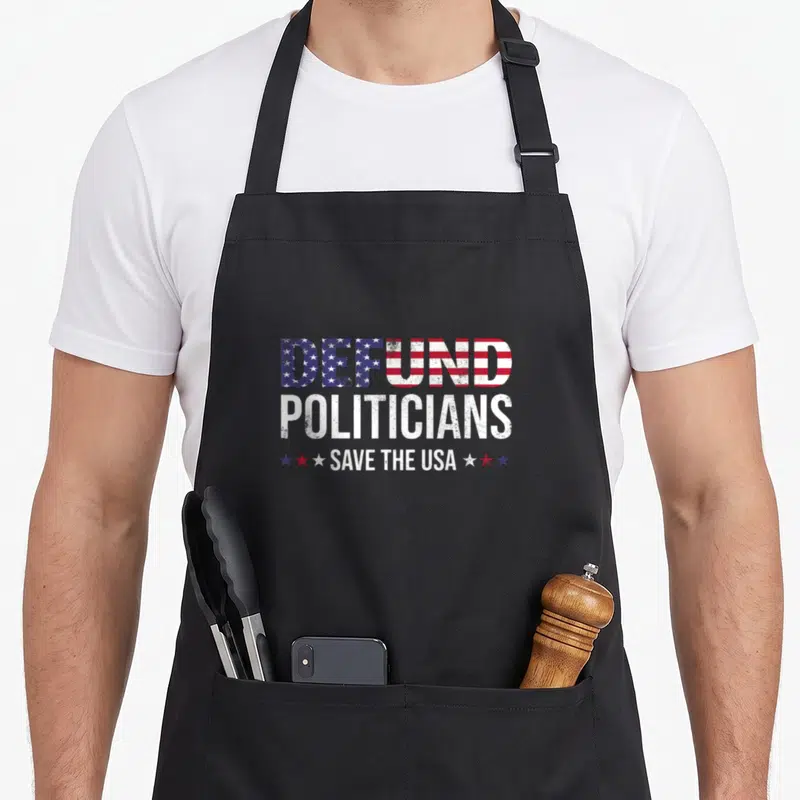 Defund politician apron - Distressed DEFUND POLITICIANS SAVE THE USA text with flag fill and three stars on each side — shown on a black cotton canvas apron against a white background