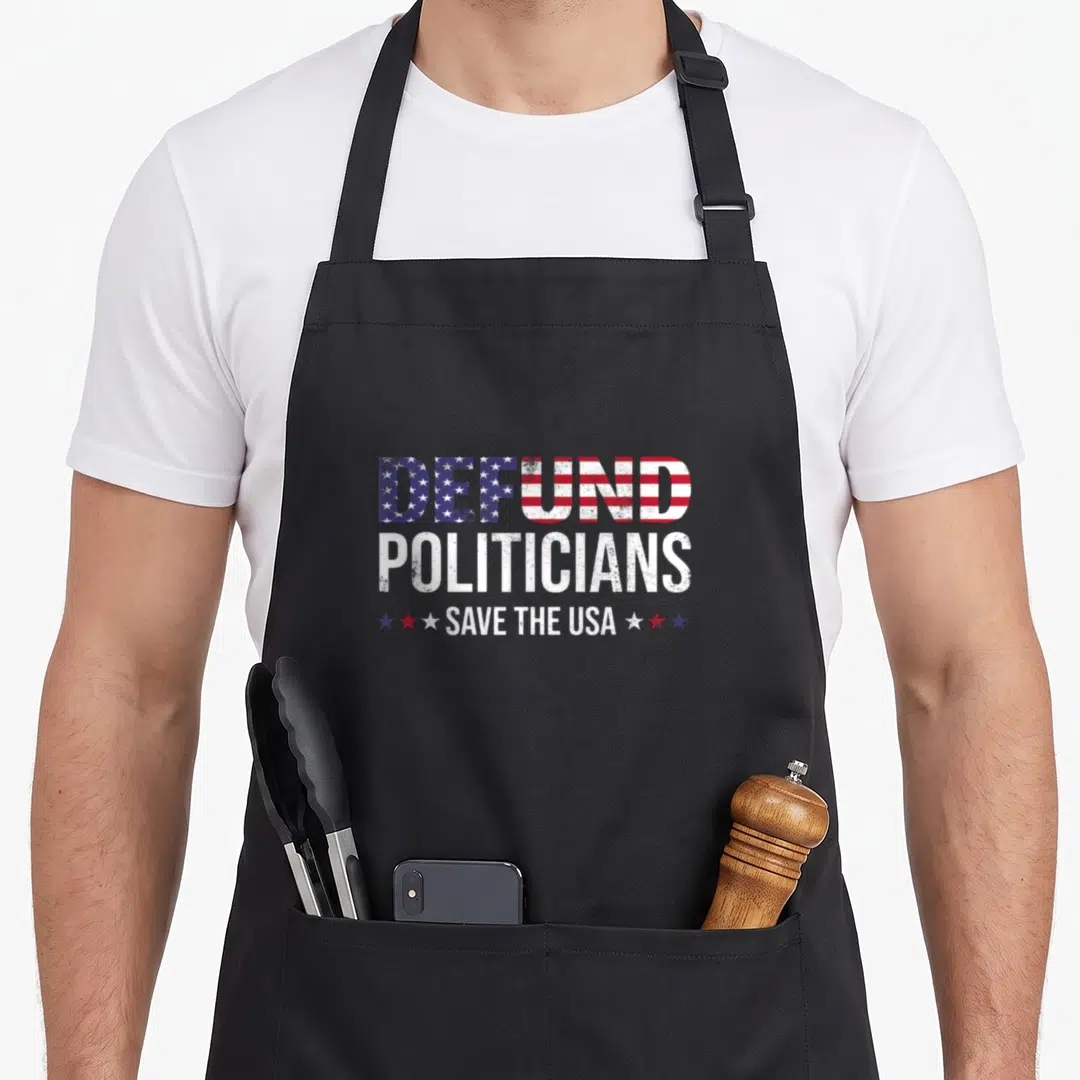 Defund politician apron - Distressed DEFUND POLITICIANS SAVE THE USA text with flag fill and three stars on each side — shown on a black cotton canvas apron against a white background