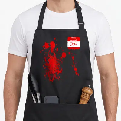 Jason halloween apron - Red and white name tag reading Hello My Name Is Jason with blood splatters — shown on a black cotton canvas apron against a white background
