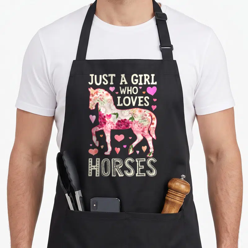 Horse horseback farm apron - Floral horse silhouette with pink hearts and text Just A Girl Who Loves Horses — shown on a black cotton canvas apron against a white background