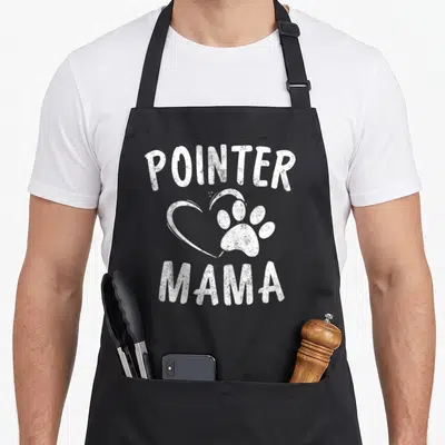 Mama pointer apron - White distressed POINTER MAMA text with heart and paw print graphic — shown on a black cotton canvas apron against a white background