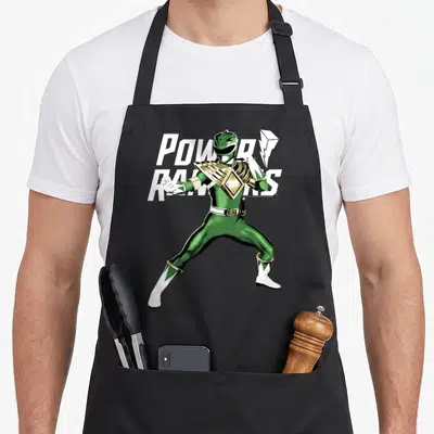 Action karate apron - Green Power Ranger standing pose with white power rangers text and gold accents — shown on a black cotton canvas apron against a white background