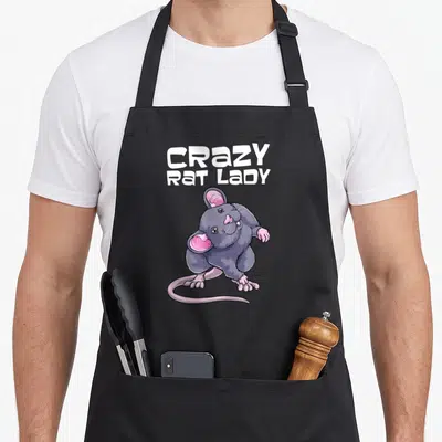 Animal obsessed rat lady apron - Cartoon grey rat with pink ears and tail below stacked white text reading CRAZY RAT — shown on a black cotton canvas apron against a white background
