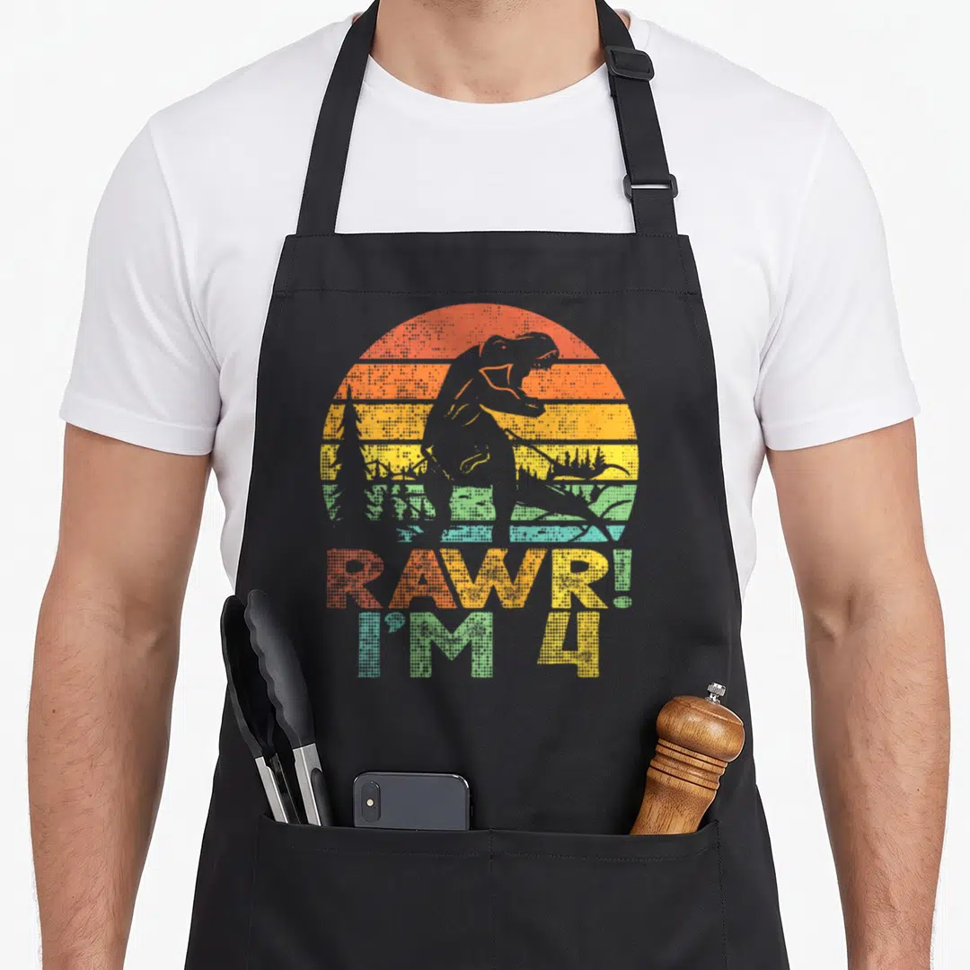 Rawr dinosaur t-rex apron - Grey T-Rex silhouette over orange yellow green blue striped sun with RAWR I M 4 text — shown on a black cotton canvas apron against a white background