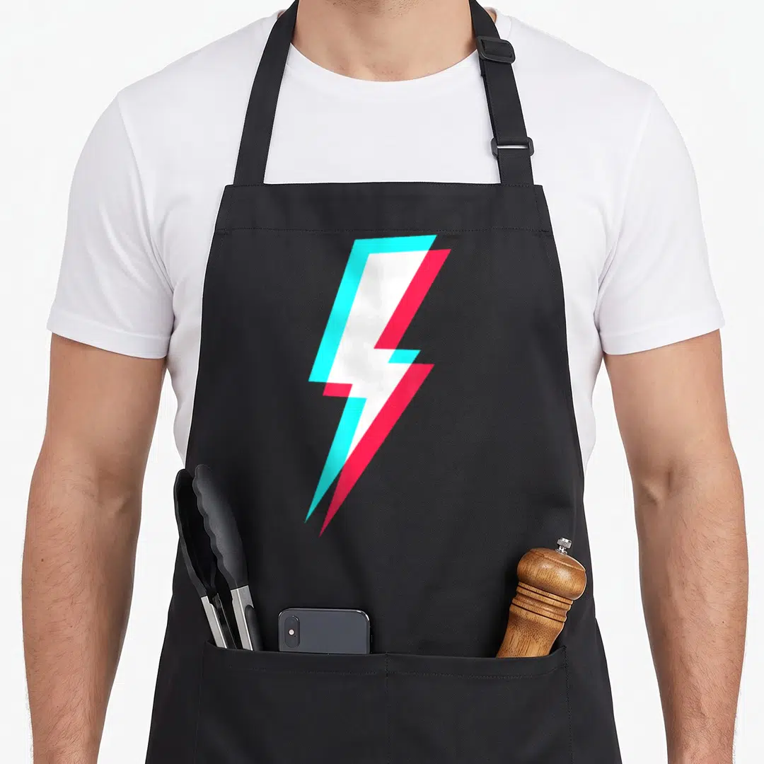 Symbol lighting bolt apron - White lightning bolt with cyan and red offset shadows on grey background — shown on a black cotton canvas apron against a white background
