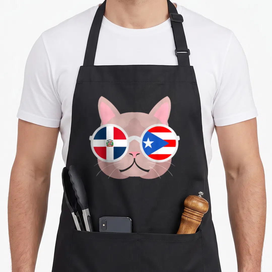 Dominirican dominican pride apron - Pink cartoon cat wearing white sunglasses with Dominican and Puerto Rican flags — shown on a black cotton canvas apron against a white background