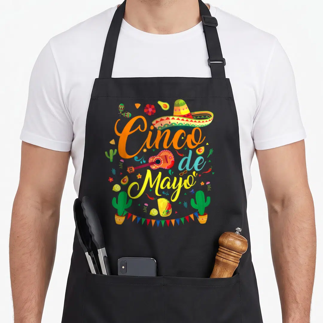 Cinco mayo mexican apron - Cinco de Mayo text with sombrero guitar tacos cacti bunting flags in cartoon style — shown on a black cotton canvas apron against a white background