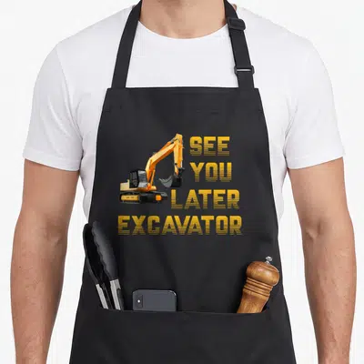 See backhoe apron - Yellow cartoon excavator beside stacked SEE YOU LATER EXCAVATOR text in striped font — shown on a black cotton canvas apron against a white background