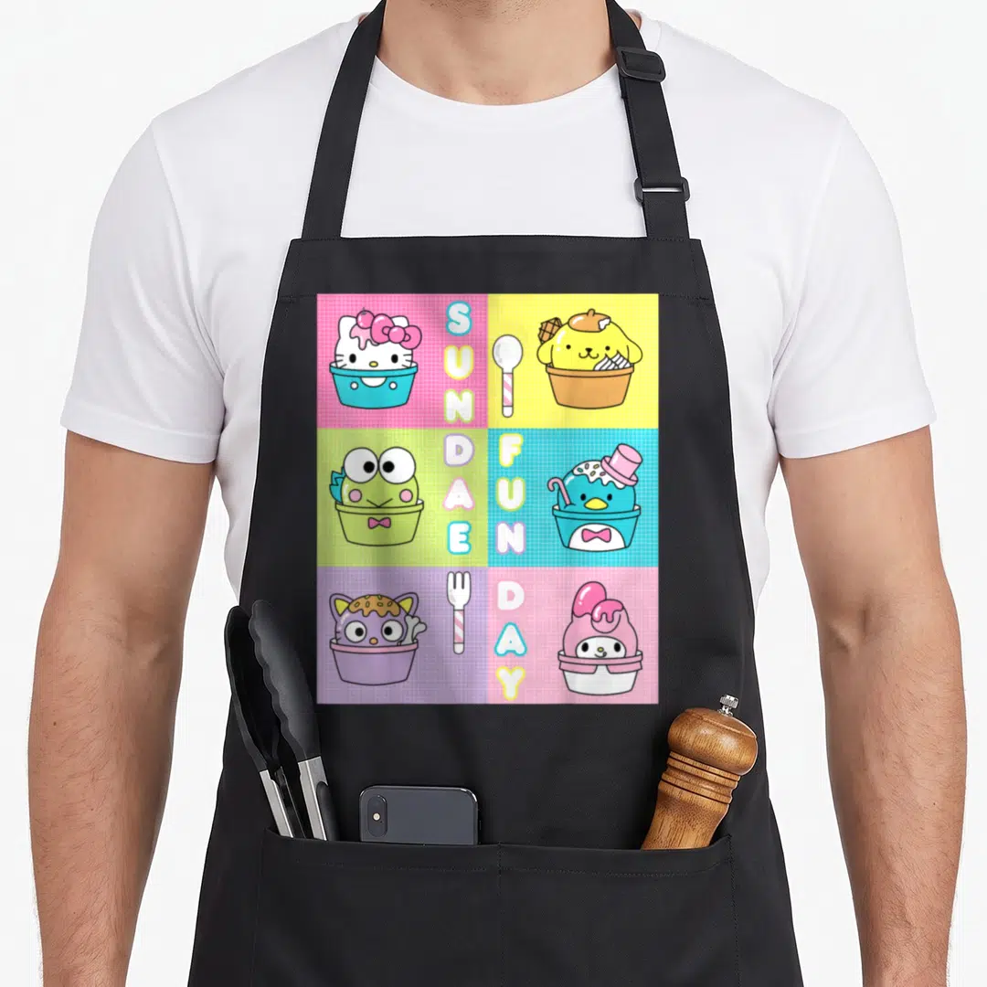 Sundae ice cream apron - Cartoon characters in ice cream cups with vertical SUNDAE FUNDAY text on pink yellow blue — shown on a black cotton canvas apron against a white background