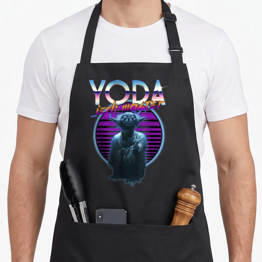 Yoda ultimate apron - Retro YODA JEDI MASTER text above Yoda figure in front of purple striped circle — shown on a black cotton canvas apron against a white background
